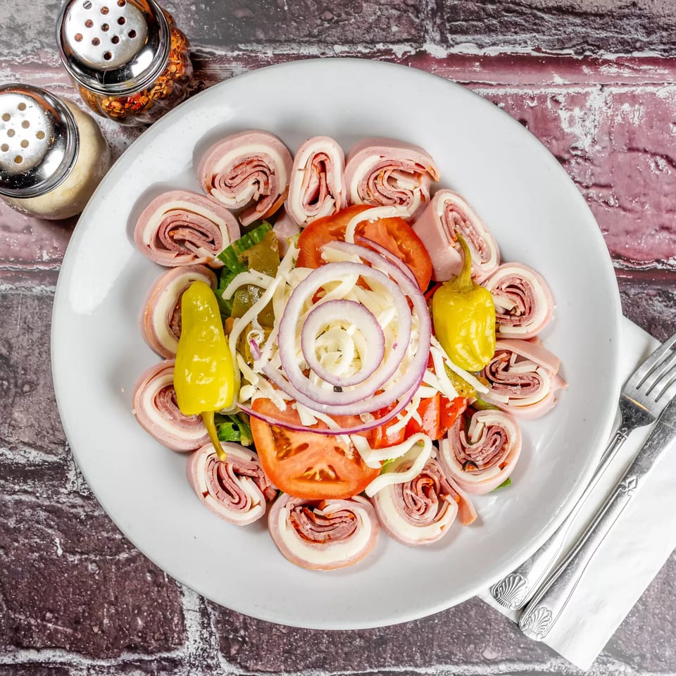 Marri's Pizza & Pasta antipasto salad with rolled meats, cheese, tomatoes, onions, and peppers.
